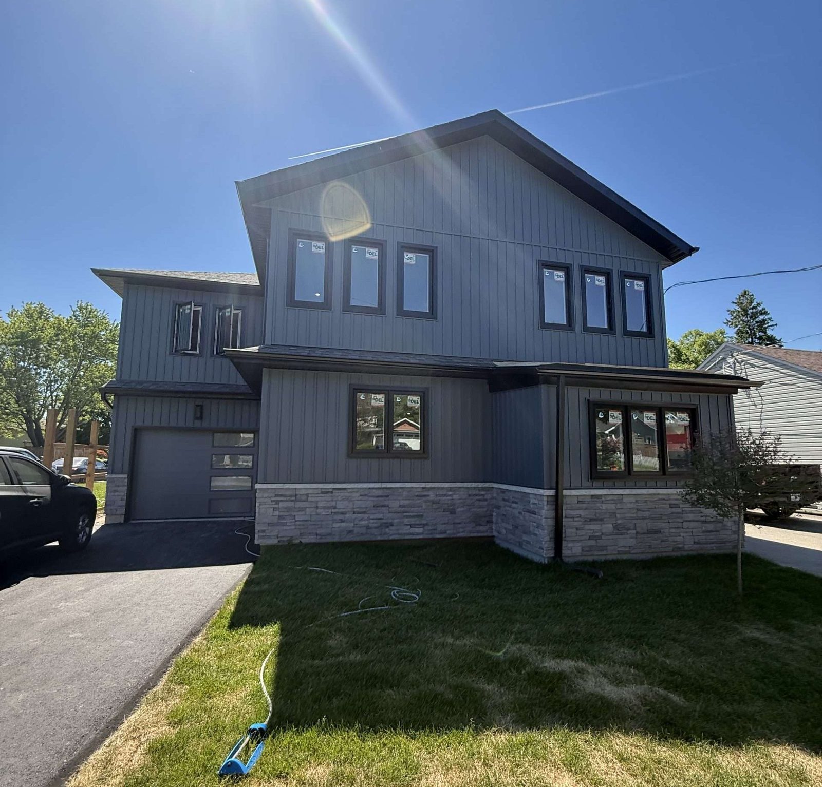Modern grey and blue two-storey home with a stone base