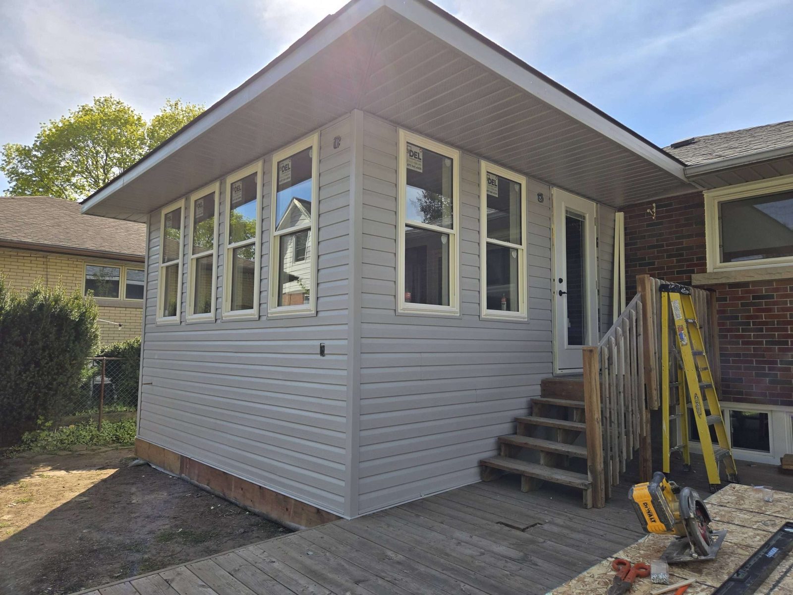 Grey-sided home exterior with new windows