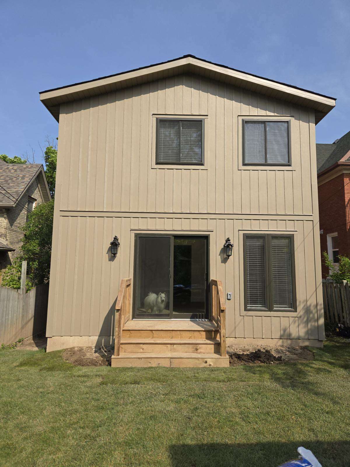 Beige two-storey home addition with wood steps built by Malamar Construction