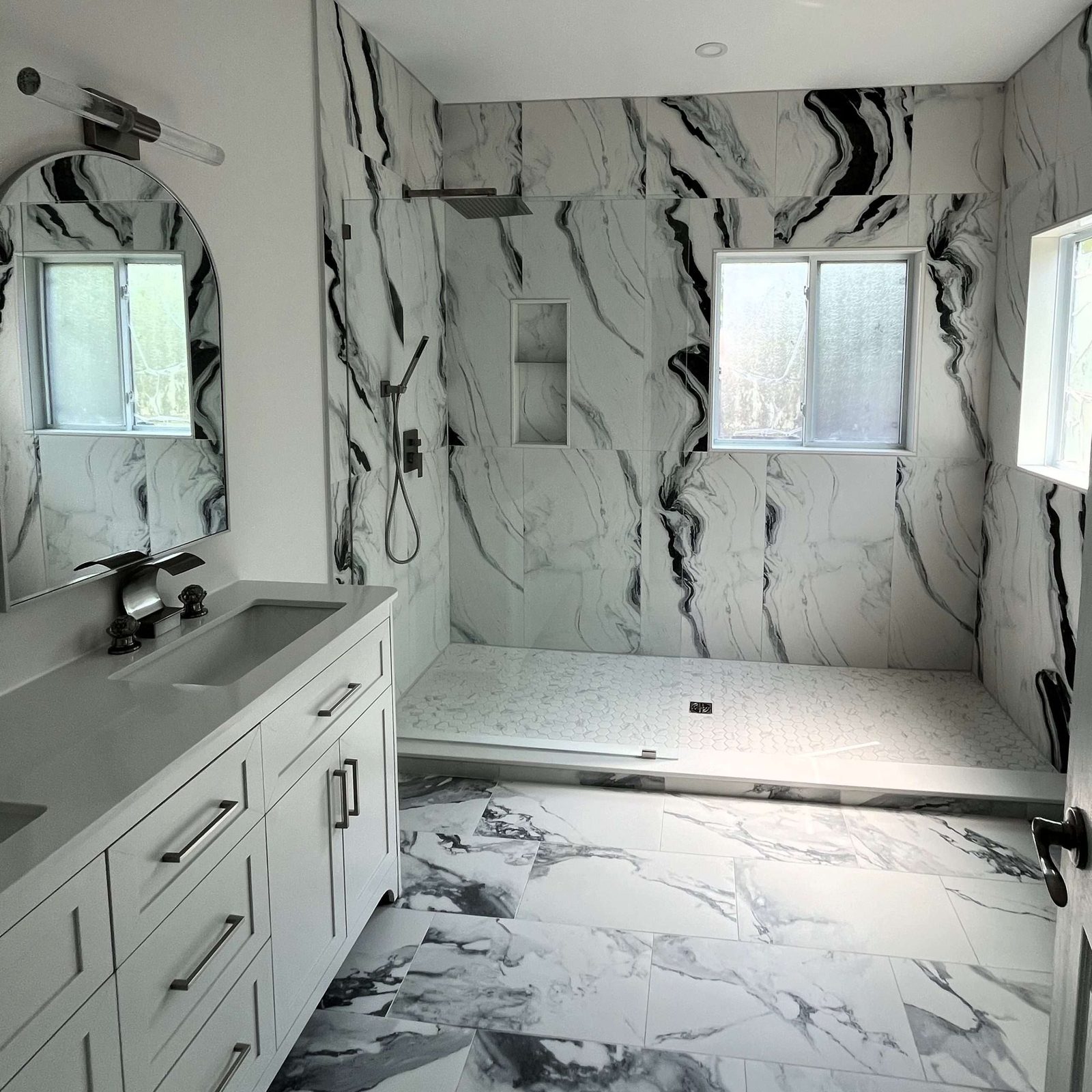 Marble ensuite with a floating vanity and glass shower