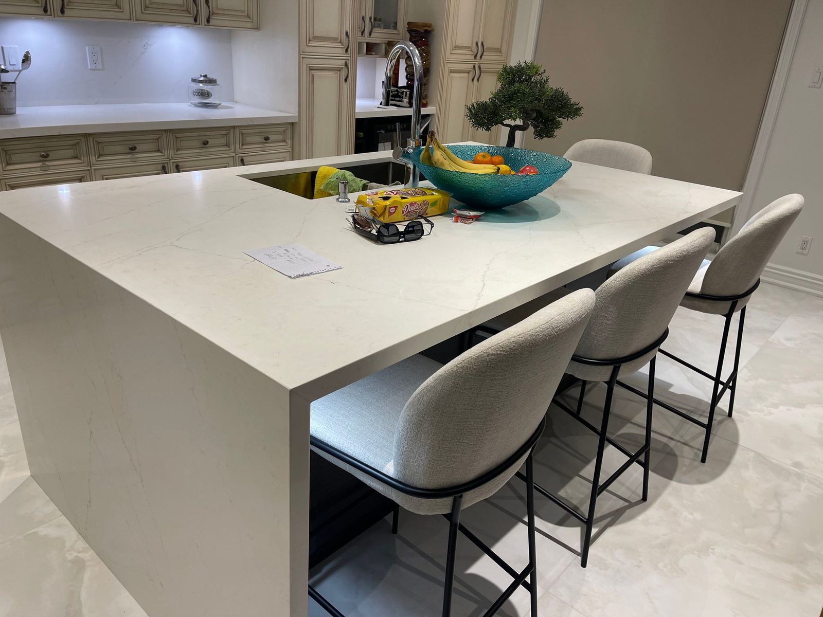 Kitchen island with a waterfall stone countertop and counter stools