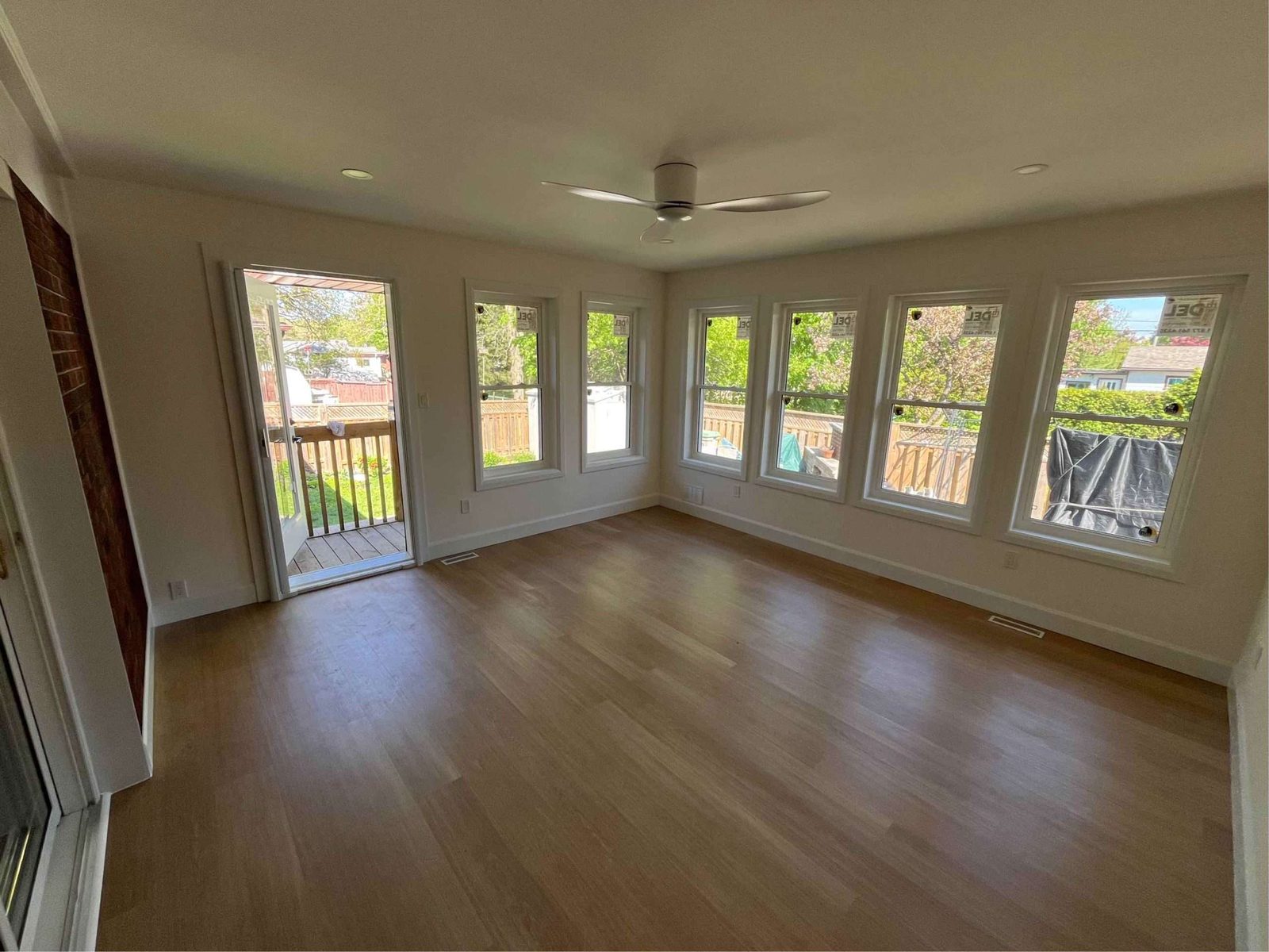 Bright sunroom addition with a wall of windows and wood floor