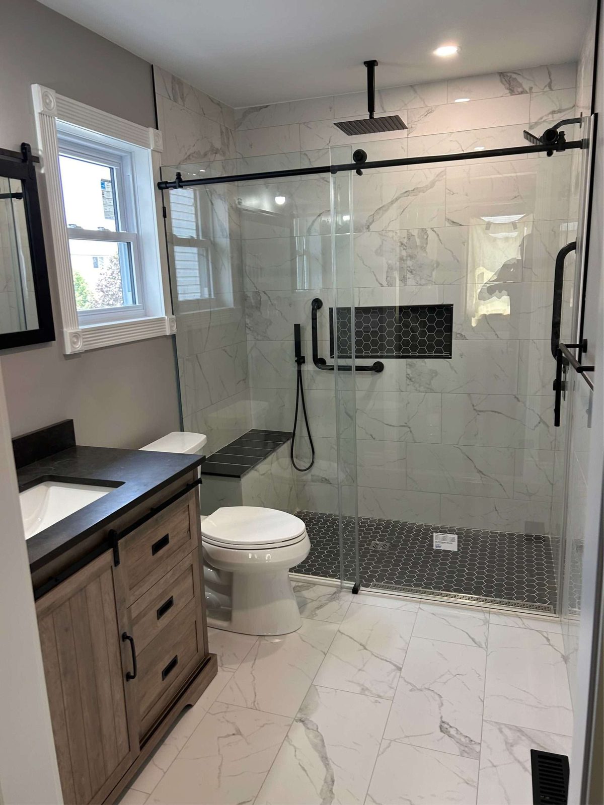 Frameless glass walk-in shower in a marble bathroom