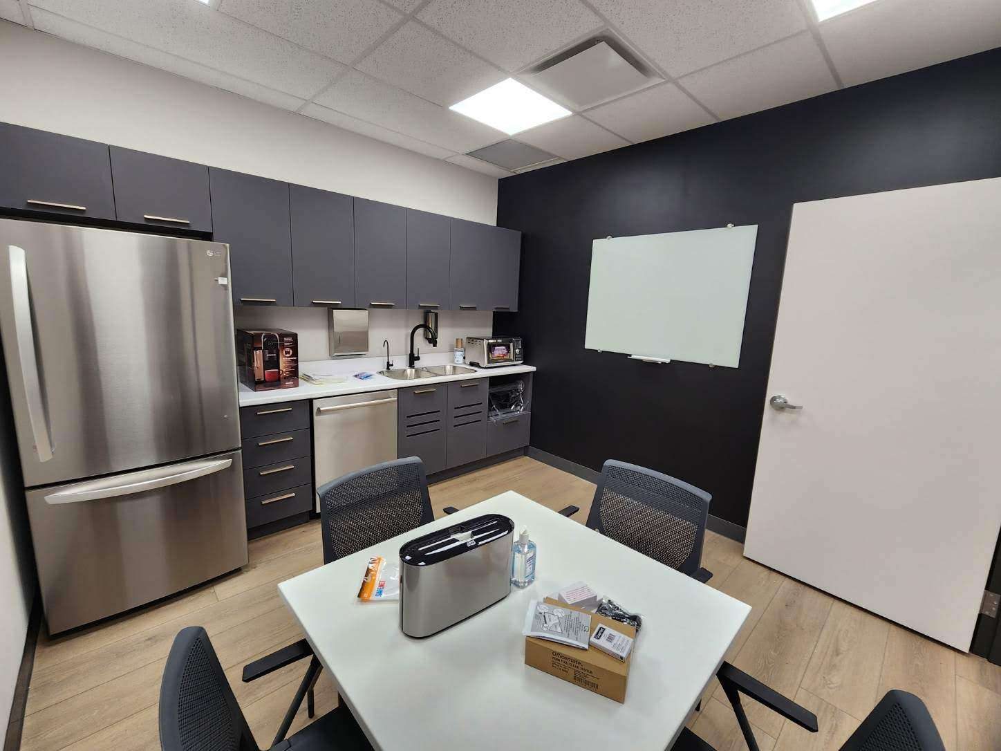 Commercial break room with a dark accent wall and full-height fridge